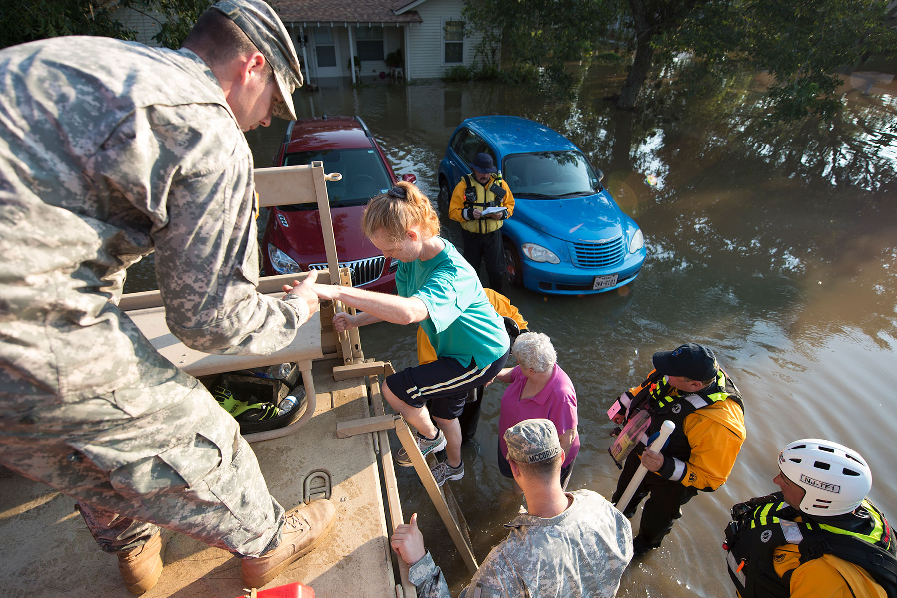 Staff Sgt. Class Richard Call, of the New Jersey National Guard, and members of New Jersey Task Force 1, assist evacuees into a Light Medium Tactical Vehicle (LMTV) to during water rescue operations in Wharton, Texas, Aug. 31, 2017. (Air National Guard/ Robert Shelley)