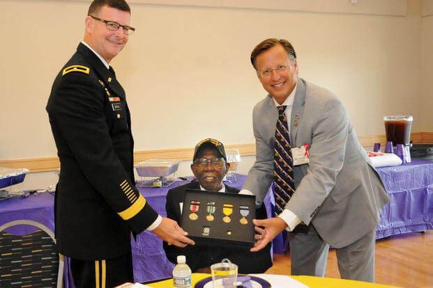 Congressman Dave Brat (right) along with Brig. Jeffrey Drushal, Chief of Transportation at Fort Lee, present the 99-year-old Richard Bell Jr. with his World War II medals during a family reunion event Aug. 26, 2017, at the Eastern Henrico Recreation Center. Bell’s great nephew and former reporter Benjamin Sessoms Jr. discovered a year ago his relative never received awards pertaining to his military service and initiated efforts for a formal presentation. (U.S. Army/Terrance Bell)