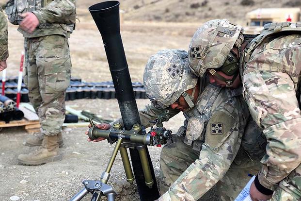 Pfc. Bryce Marcille, left, with Headquarters and Headquarters Company, 2nd Battalion, 12th Infantry Regiment, 2nd Infantry Brigade Combat Team, sets the elevation on an 81mm mortar system as Spc. Brian Torres, right, monitors through the sight piece during range training at Fort Carson, Colo., on Jan. 25, 2018. Several 2-12 Infantry soldiers conducted range qualification training in preparation for the War Horse Brigade’s upcoming deployment to Afghanistan. (Photo by Spc. Connor Owens/Army)
