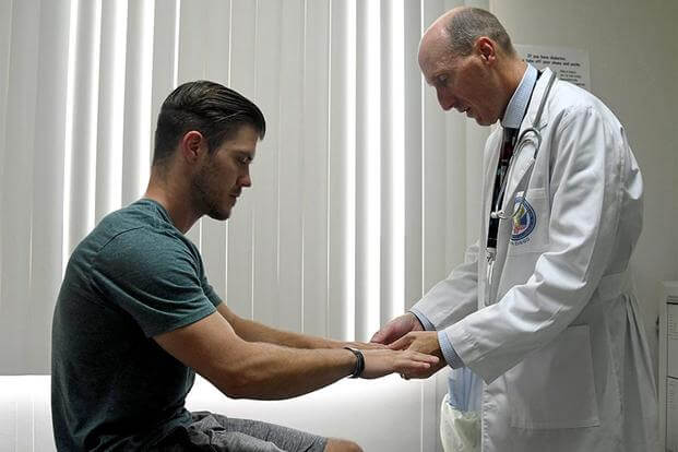 Doctor checks the hands of a patient. (Image: Department of Veterans Affairs)