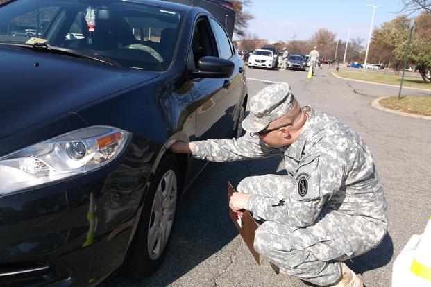 Sgt. 1st Class Raymond M. Richardson, a kennel master with the 289th Military Police Company, checks the tire tread on a car during a safety inspection of the vehicles of Soldiers assigned to the company Nov. 24, 2014. (Julia LeDoux/U.S. Army)