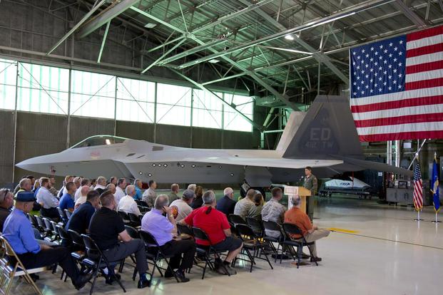 Lt. Col. Lee Bryant addresses base leadership along with Lockheed Martin and Boeing representatives, to welcome back to life Raptor # 91-4006, which has been on the ground for almost six years. (Courtesy photo by Christopher Higgins/Lockheed Martin)