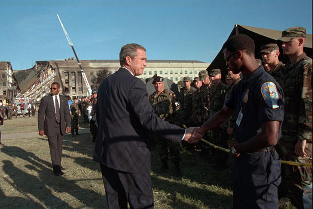 President George W. Bush greets rescue workers, firefighters and military personnel, Sept. 12, 2001, while surveying damage caused by the previous day’s terrorist attacks on the Pentagon. (Photo by Eric Draper, Courtesy of the George W. Bush Presidential Library) 
