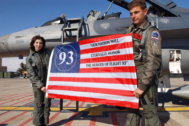 Sandra Dahl, left, is the widow of Jason Dahl, the pilot of United Airlines Flight 93, which went down in Somerset, Pennsylvania, on Sept. 11, 2001. The plane was believed to have been en route to the White House. Here, she holds an American flag along with Air Force Lt. Col. Mike Low after flying in the back seat of his F-16 Fighting Falcon fighter. (Air Force photo by Tech Sgt. Darin Overstreet)