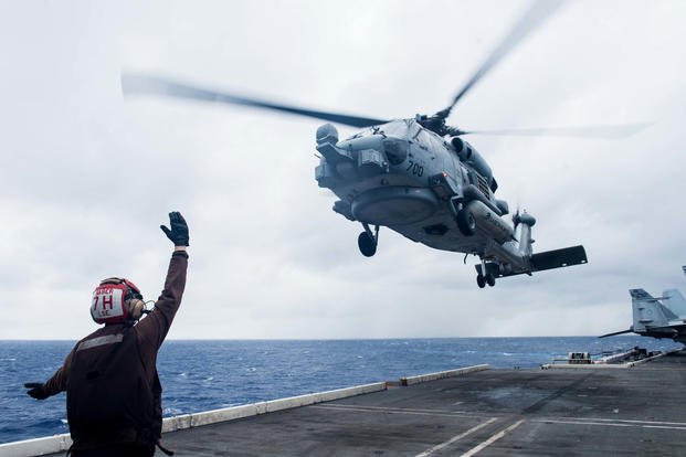 A sailor assigned to Helicopter Maritime Strike Squadron (HSM) 77 directs an MH-60R Sea Hawk as it launches from the flight deck of the Navy’s forward-deployed aircraft carrier USS Ronald Reagan (CVN 76) during Valiant Shield 2018, September 20, 2018. (U.S. Navy/Kenneth Abbate)