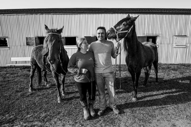 Tiffany Wisley, Langley Saddle Club head feeder, and U.S. Air Force Staff Sgt. Cody Wisley, 83rd Network Operations Squadron boundary protection supervisor, pose for a photo with their horses Spooks and Steel at the stables on Joint Base Langley-Eustis, Virginia. (U.S. Air Force/Areca T. Bell)