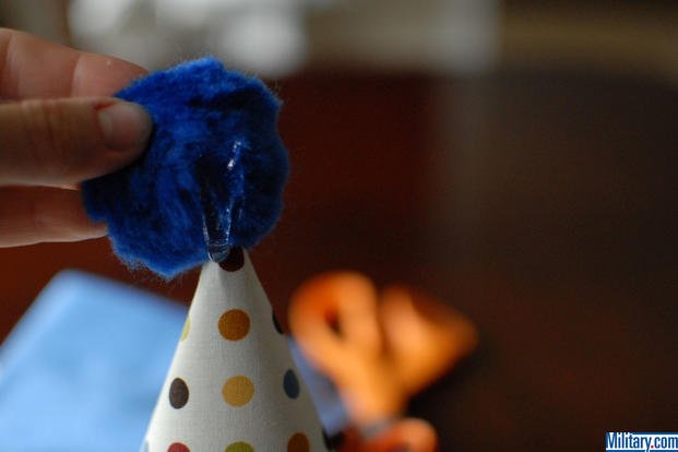 Glue the pom-pom on your care pacakage birthday hat. (Military.com)