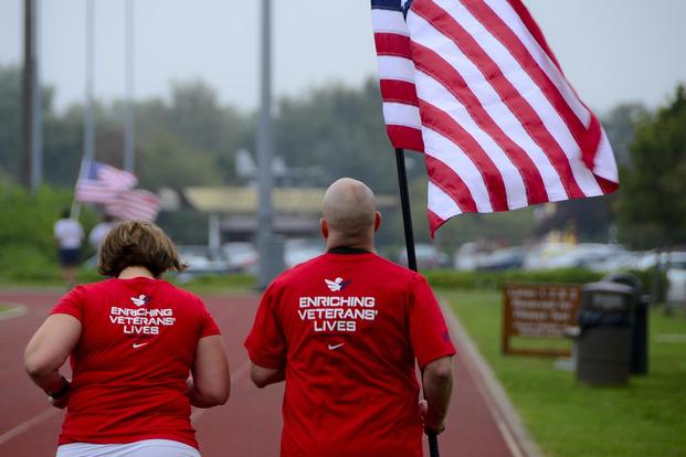 Tech. Sgt. Jennifer Aucoin, 48th Maintenance Group training manager, runs with her husband, Master Sgt. Jason Aucoin, 48th Fighter Wing ground safety office manager, during a 9/11 Memorial 5K Run/Walk "Moving Tribute" at Royal Air Force Lakenheath, England, Sept. 11, 2014. (U.S. Air Force/Airman 1st Class Erin O'Shea)