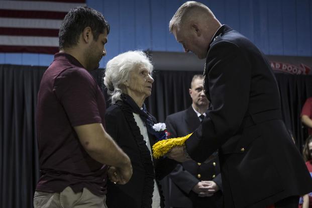 Maj. Gen. Bradley S. James, commander of Marine Forces Reserve and Marine Forces North, presents the Medal of Honor flag to Sgt. Alfredo Cantu Gonzalez’s mother, Dolia Gonzalez, at the Freddy Gonzalez Elementary school in Edinburg, Texas, Jan. 14, 2019. (U.S. Marine Corps/Cpl. Tessa D. Watts)