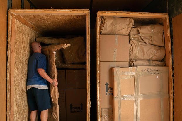 Movers pack a military members property into boxes and load it into crates to be transferred to a temporary storage facility in O'Fallon, Illinois, July 1, 2019. (U.S. Air Force photo/Stephenie Wade)