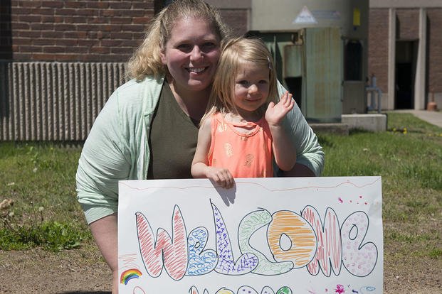 mother daughter with welcome home sign