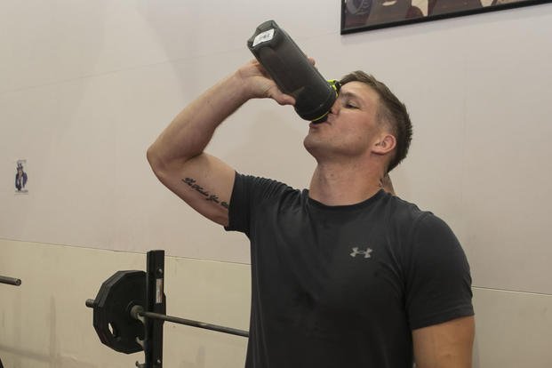 Marine drinks a protein shake between workouts.