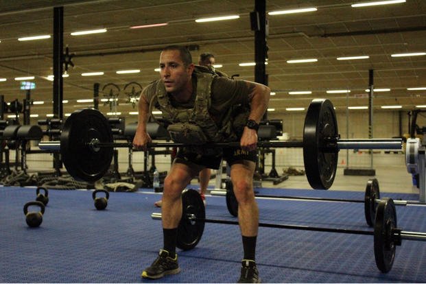 A captain completes barbell rows during a memorial workout.
