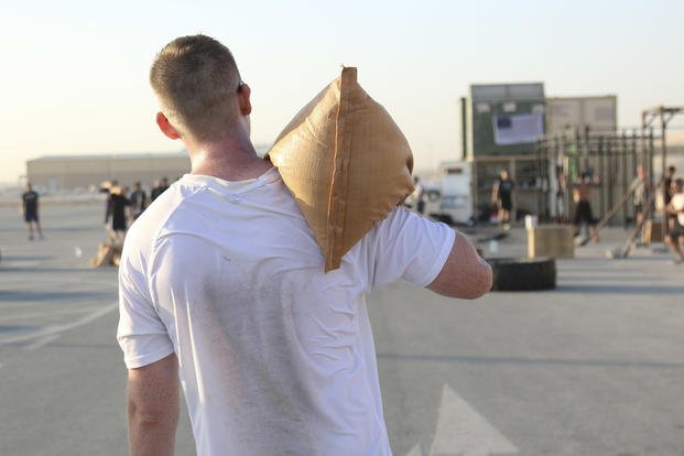 An Army sergeant completes the sandbag carry during a memorial CrossFit workout.