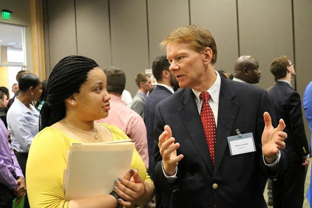 Steve Fisher, the U.S. Army Aviation and Missile Command human resources training manager, speaks with a recent graduate during the AMCOM Job Fair at Redstone Arsenal, Alabama.
