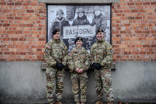 Three modern-day 101st Airborne troops now in Bastogne in front of a photo of 101st leaders who defended the town in December 1944. (Photo courtesy of the 101st Airborne Division)
