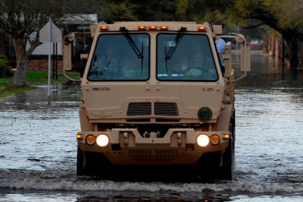 A Texas Army National Guard Light Medium Tactical Vehicle drives through flooded streets in Orange, Texas, March 17, 2016. (Photo by Alicia Lacy/Air National Guard)