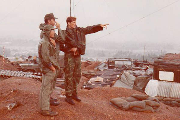 Then-Maj. William Collier, center, with his translator, Mr. Long, left, and then-Air Force Capt. Joseph Personett look out over the burm of Mo Duc District Headquarters, Vietnam, in 1972.