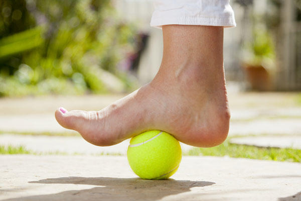 Foot massage with tennis ball