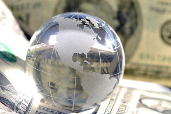 Reflective globe on money stack.