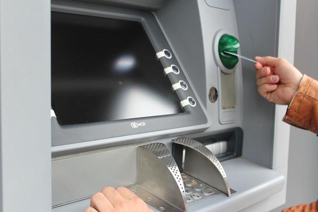 person inserting card in ATM