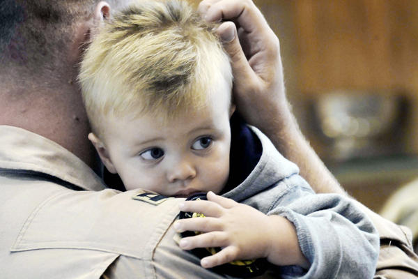A servicemember holding his son.