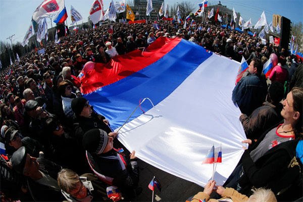 Pro-Russian activists hold a huge Russian national flag in front of the regional administration building in Donetsk, Ukraine, Sunday, April 6, 2014. (AP Photo/Andrey Basevich)