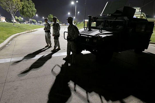 Members of the Missouri National Guard stand watch outside a command post near a protest Monday, Aug. 18, 2014, for Michael Brown, who was killed by a police officer Aug. 9 in Ferguson, Mo. (AP Photo/Charlie Riedel)