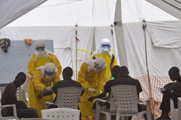 Health workers, attend to patients that contracted the Ebola virus, at a clinic in Monrovia, Liberia, Monday, Sept. 8, 2014 (AP Photo/Abbas Dulleh)