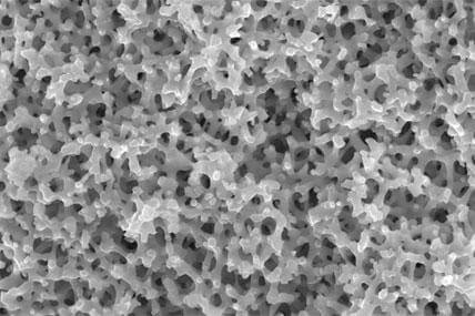 A close-up view of the nanofoam material, a porous silica with an average pore size of a few microns, seen at the 5-micron scale.