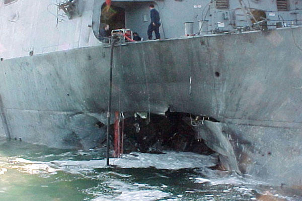 Port side view showing the damage sustained by the USS Cole on Oct. 12, 2000, after a terrorist bomb exploded during a refueling operation in the port of Aden, Yemen. DoD photo.