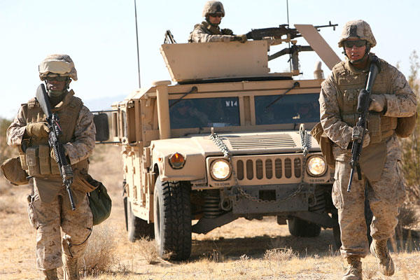 Pfc. Justin Jones and Lance Cpl. Martin Carranza lead their Humvee on an alternate route to bypass a possible simulated improvised explosive device. (Marine photo)