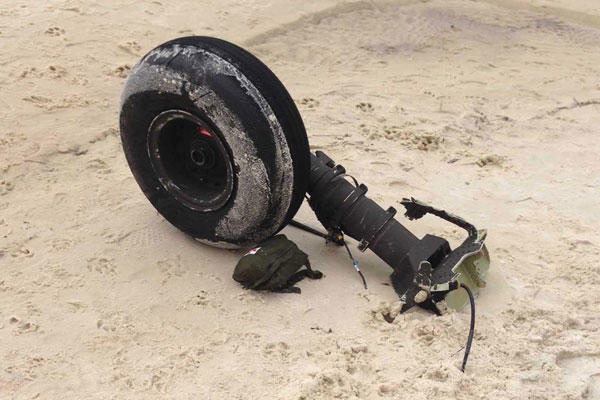 Part of a wheel assembly of what could be the wreckage of a UH-60 Black Hawk helicopter sits on on Riviera Beach in Navarre, Fla., Wednesday, March, 11, 2015. (AP Photo/Northwest Florida Daily News, Jennie McKeon)