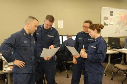 Members of the Coast Guard Sector Anchorage, Alaska, Incident Management Team for the Alaska Shield 2014 exercise examine data during a morning meeting March 31, 2014.