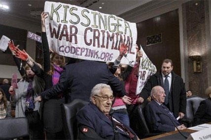Protesters interrupt the start of a Senate Armed Services hearing, on Capitol Hill, Thursday, Jan. 29, 2015, as they shout at former Secretary of State Henry Kissinger, center. (AP Photo/J. Scott Applewhite)