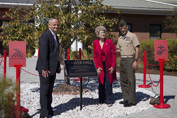 Betsy Fowler, widow of Col. James Fowler founder of the Marine Corps Marathon, poses with guests after unveiling the plaque at the Marine Corps Marathon building dedication at Marine Corps Base Quantico, Virginia. (U.S. Marine Corps/Sgt. Melissa Karnath)