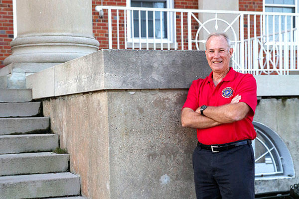 Kevin Scott, manpower, personnel and training lead for Combat Support Systems at Marine Corps Systems Command, stands in front of the command’s headquarters building aboard Marine Corps Base Quantico, Virginia. (U.S. Marine Corps/Mathuel Browne)