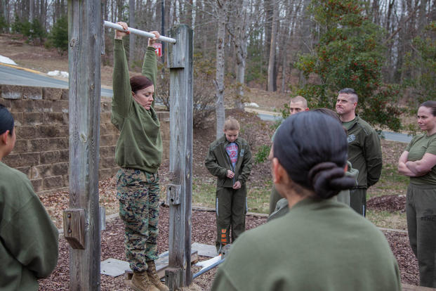 Major Misty Posey, center, demonstrates proper form for pull-ups to Marines at Marine Corps Base Quantico, Virginia, Feb. 19, 2016. (Photo: Sgt. Dylan Bowyer)