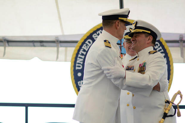 Capt. Anthony Ceraolo (right), new commanding officer of Sector San Francisco, salutes and hugs Capt. Greg Stump (left) during a change of command ceremony in San Francisco, Tuesday July 19, 2016. (Photo: Petty Officer 3rd Class Adam Stanton)
