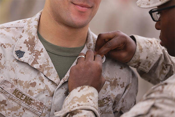 U. S. Marine Master Sgt. Jimi G. H. Liddel Gayden, attached to the 11th Marine Expeditionary Unit, pins sergeant chevrons on Sgt. Brandon N. Keens, at Marine Corps Base Camp Pendleton, Calif., July 1, 2013. (Cpl. Jonathan Waldman)
