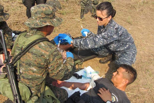 Hospital Corpsman 2nd Class Loany Saldivar provides guidance to one of the testing groups on how to properly and safely administer and intravenous fluids to a patient in the field. (Navy photo courtesy of HM2 Saldivar)