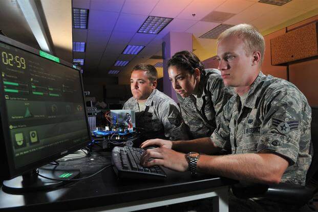 Three airmen perform cyber operations at Lackland Air Force Base, Texas, Aug. 1, 2012. (U.S. Air Force/Boyd Belcher)
