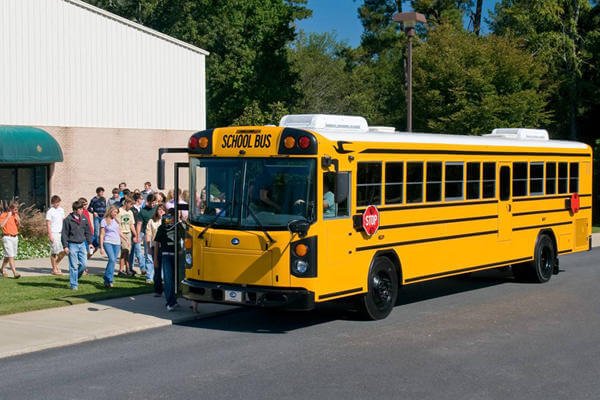 School bus picking up high school students.