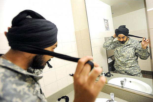 Spc. Simranpreet Singh Lamba, a combat medic, demonstrates tying a 5-meter-long turban May 23, 2011. Lamba's religion asks that he never cut his hair. He was the first enlisted Sikh soldier in more than three decades. Ingrid Barrentine/Northwest Guardian