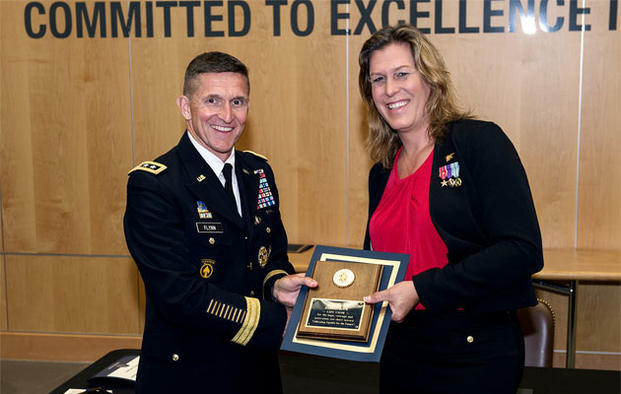 Retired Navy SEAL Kristin Beck receives a plaque in June 2014 from Defense Intelligence Agency Director Lt. Gen. Michael Flynn, following the agency’s Pride Month event. (DIA photo)