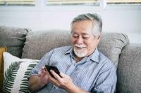 Elderly man reading text message on smartphone