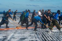 Sailors assigned to Nimitz-class nuclear aircraft carrier USS Carl Vinson (CVN 70) sweep the flight deck