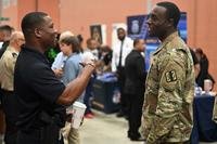 U.S. Army Brig. Gen. Leland D. Blanchard II, Commanding General (Interim) of the D.C. National Guard, and members of the D.C. National Guard Recruiting and Retention Battalion (RRB) join more than 27 federal and local law enforcement agencies for the DMV Law Enforcement Career Fair at MPD Academy, in Washington, D.C., on Sept. 27, 2025. The multi-agency recruiting event was hosted by the Metropolitan Police Department Recruiting Unit and attended by more than 1,100 jobseekers. More than 120 registrants were National Guard members supporting the D.C. Safe and Beautiful mission. (Master Sgt. Arthur M. Wright/Army National Guard) A solider talks to a police recruiter at a job fair.