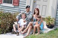 A soldier and his family sits on the front stoop. (Photo: U.S. Army)