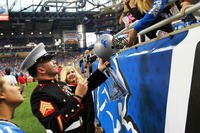 U.S. Marine Sgt. Benjamin J. Annarino signs a fan’s helmet during a Detroit Lions football game at Ford Field in Detroit, Oct. 20, 2015. (Photo by: Sgt. J. R. Heins)